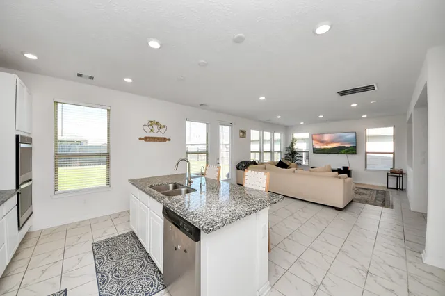 a kitchen with granite countertop living room and white cabinets