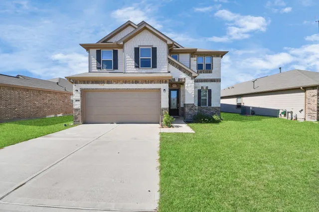 a front view of a house with a yard and garage