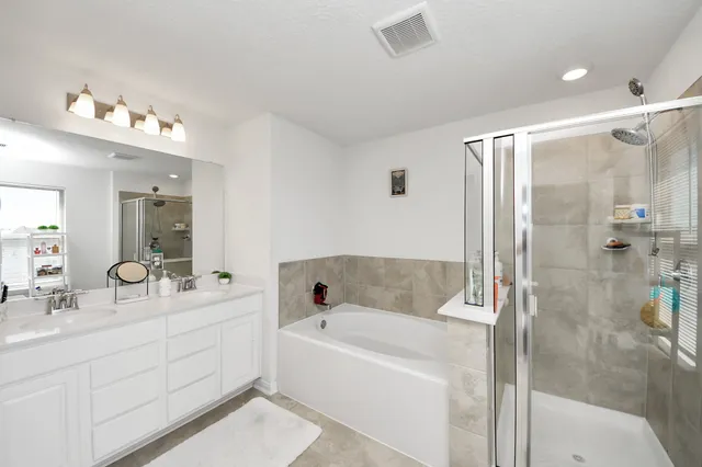 a bathroom with a tub a sink shower and mirror