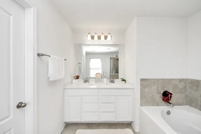 a bathroom with a sink tub and a mirror