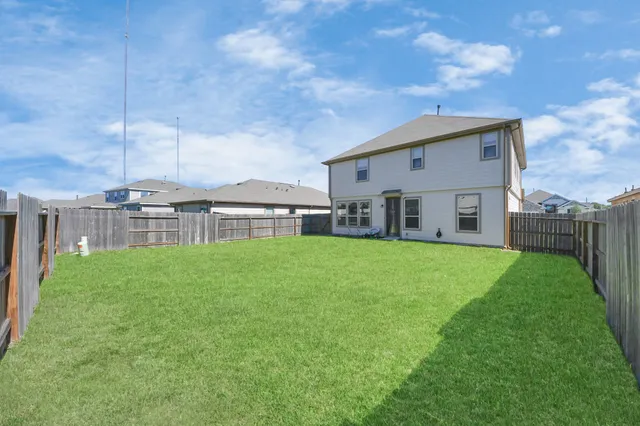 a view of a house with a big yard and large trees