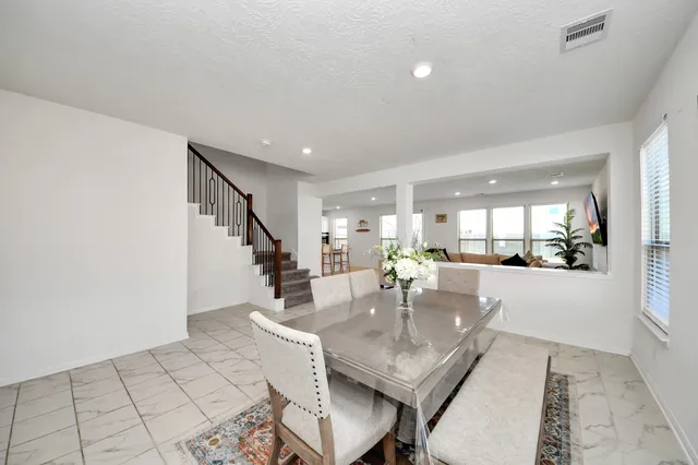 a dining room with furniture and a floor to ceiling window