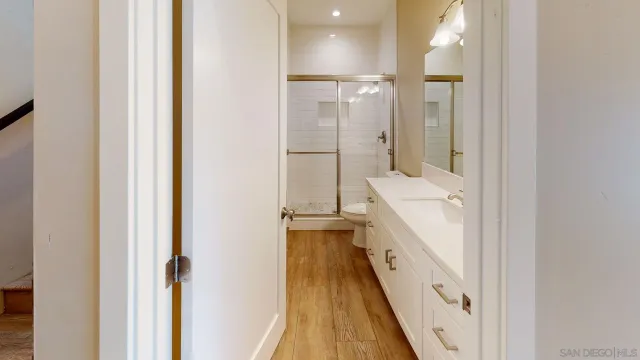 an empty room with wooden floor and a ceiling fan