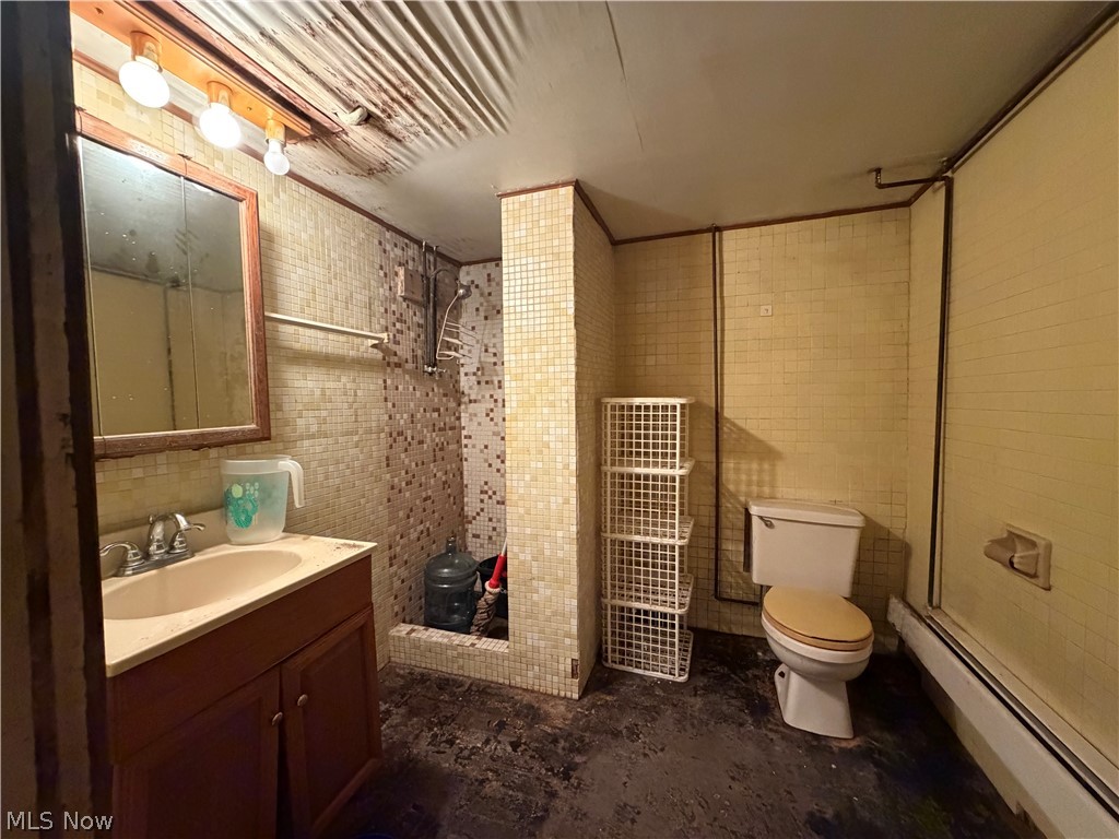 3246 Tabor Ridge Road Northeast Mineral City, OH 44656 - Photo 16 of 29 Bathroom featuring a vanity with an integrated sink, a framed medicine cabinet, and a tiled shower stall