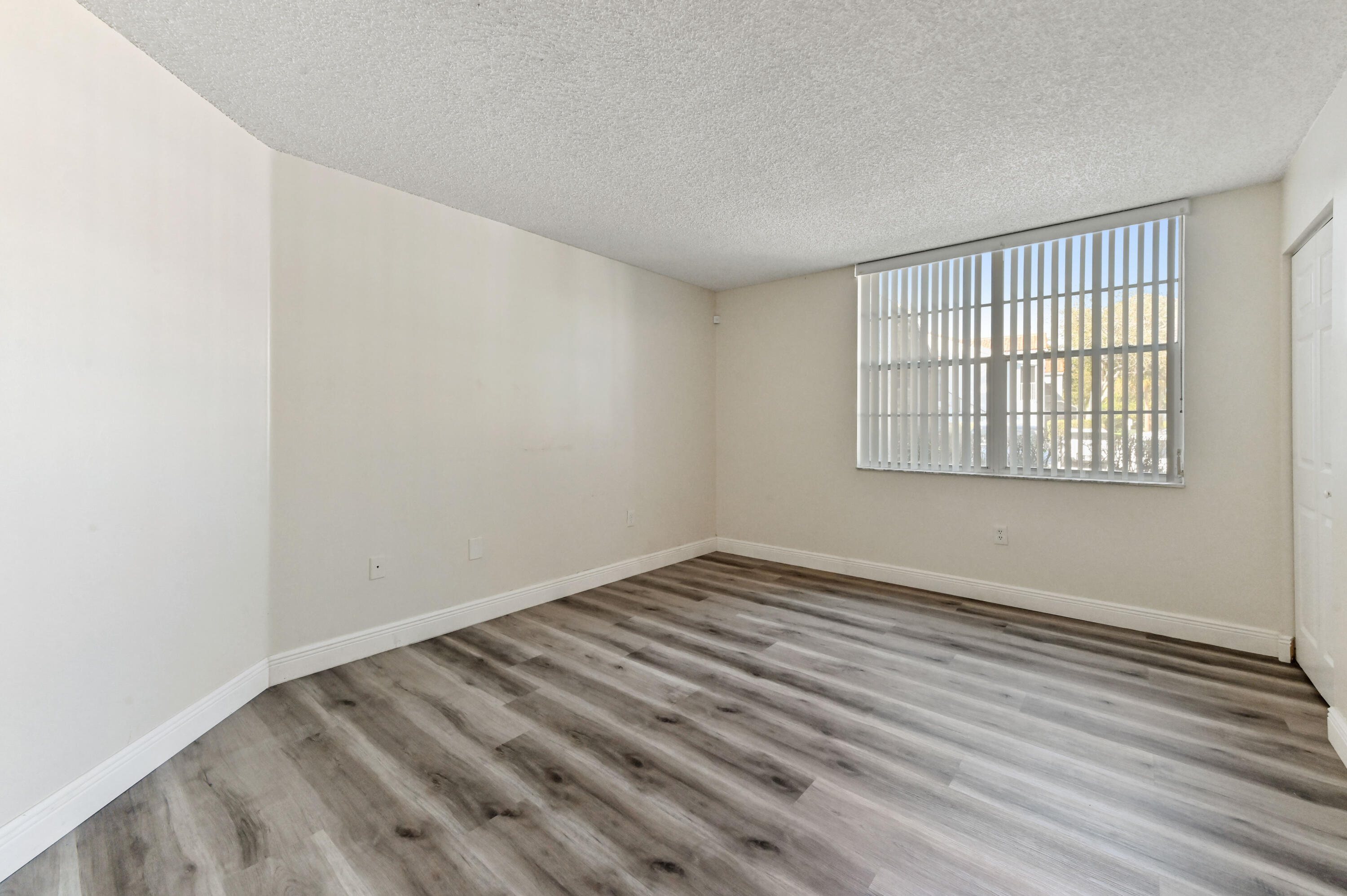3237 Clint Moore Road, Unit 107 Boca Raton, FL 33496 - Photo 12 of 41 wooden floor in an empty room with a window