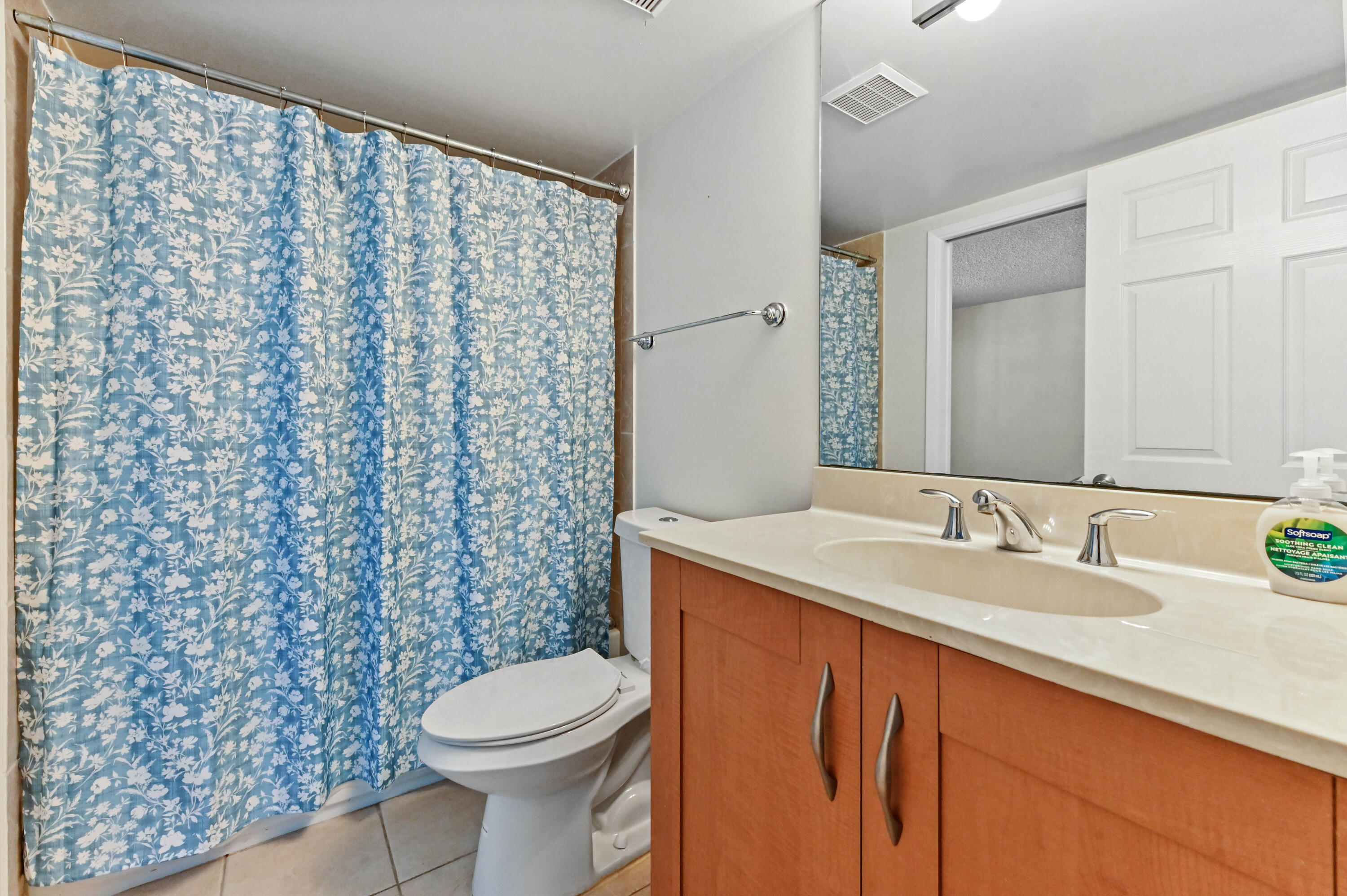 3237 Clint Moore Road, Unit 107 Boca Raton, FL 33496 - Photo 14 of 41 a bathroom with a sink a toilet and shower curtain