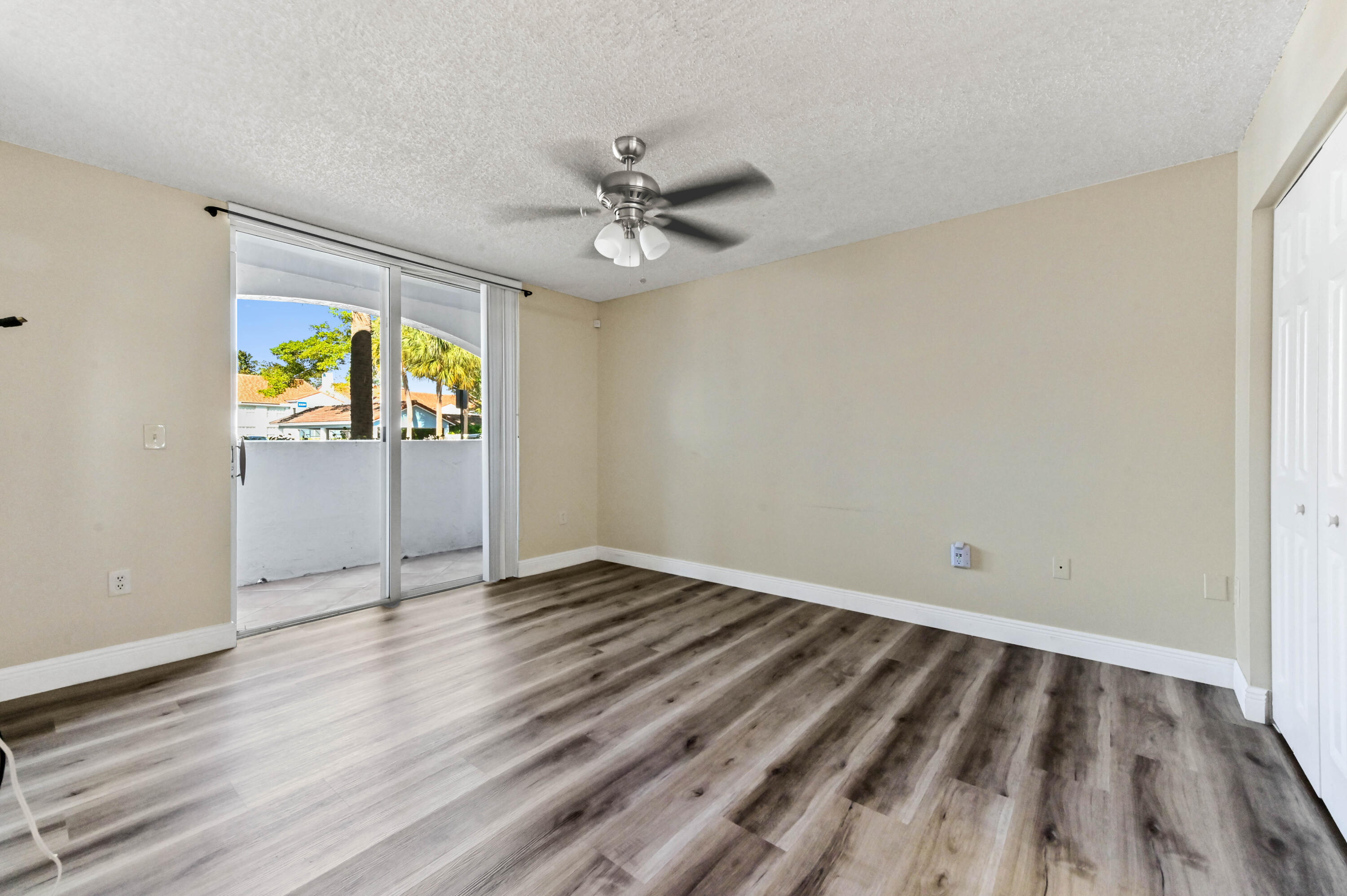 3237 Clint Moore Road, Unit 107 Boca Raton, FL 33496 - Photo 15 of 41 wooden floor in an empty room with a window