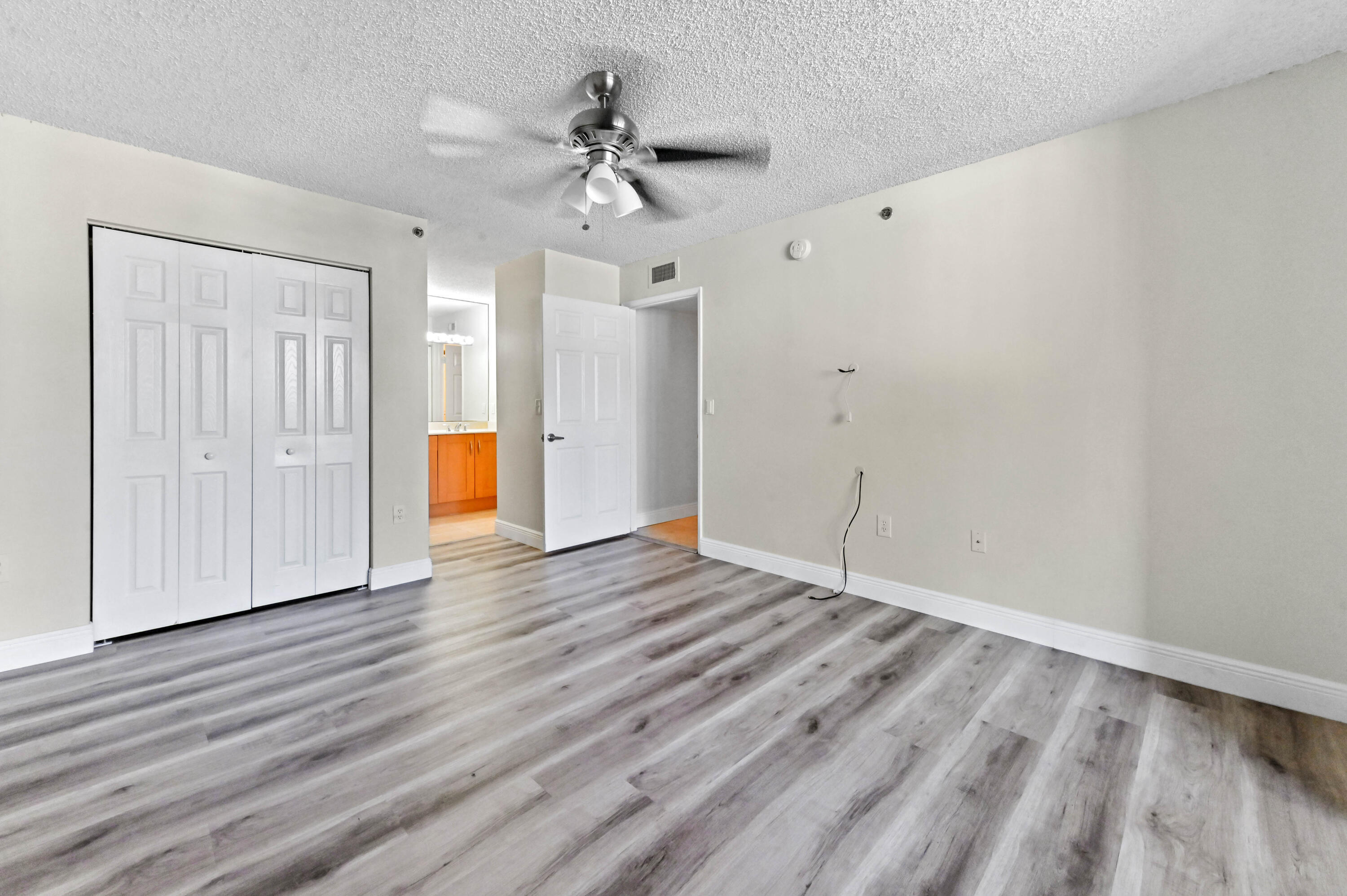 3237 Clint Moore Road, Unit 107 Boca Raton, FL 33496 - Photo 16 of 41 a view of an empty room with wooden floor