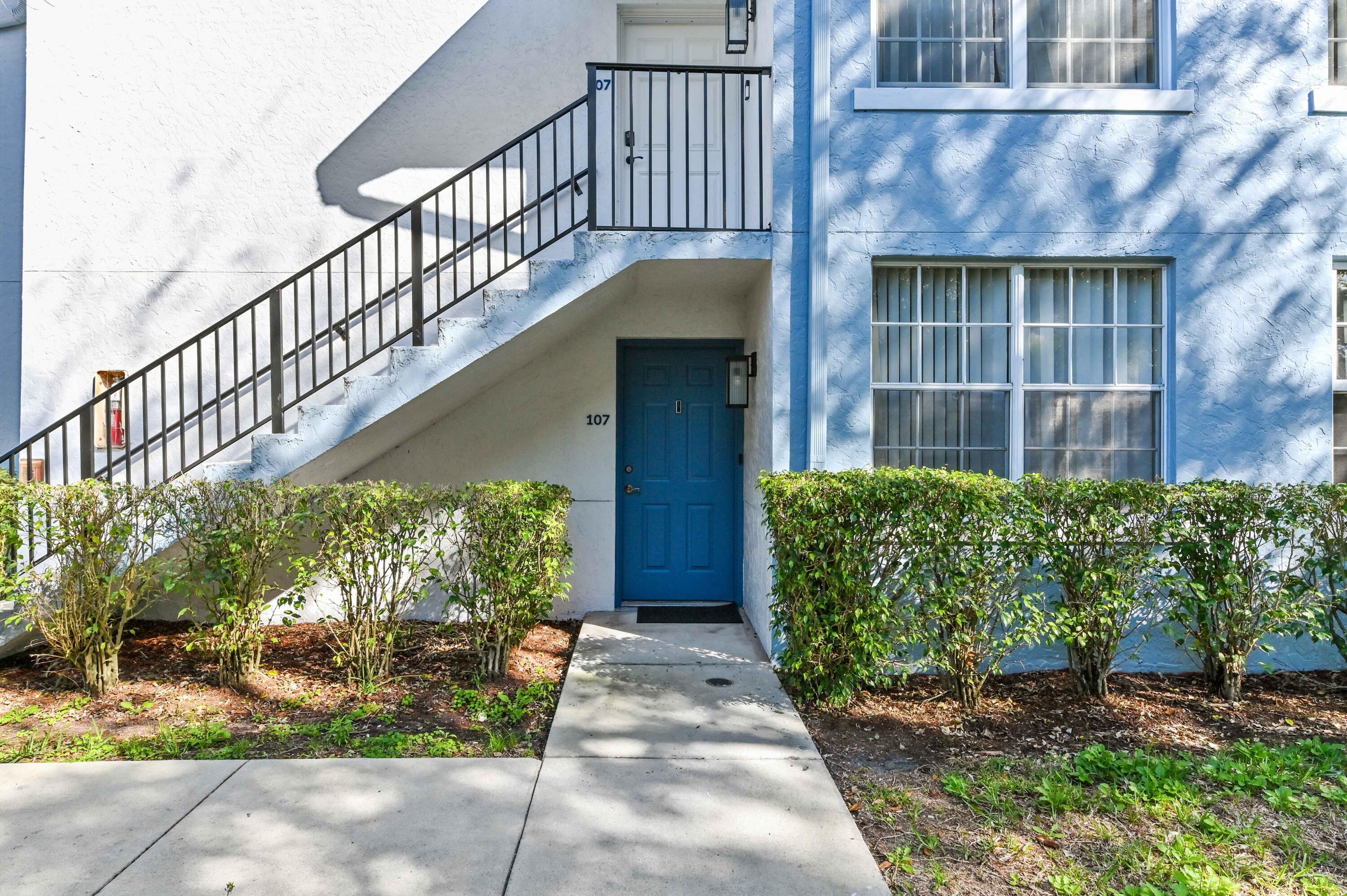3237 Clint Moore Road, Unit 107 Boca Raton, FL 33496 - Photo 2 of 41 a view of a house with plants and a small yard