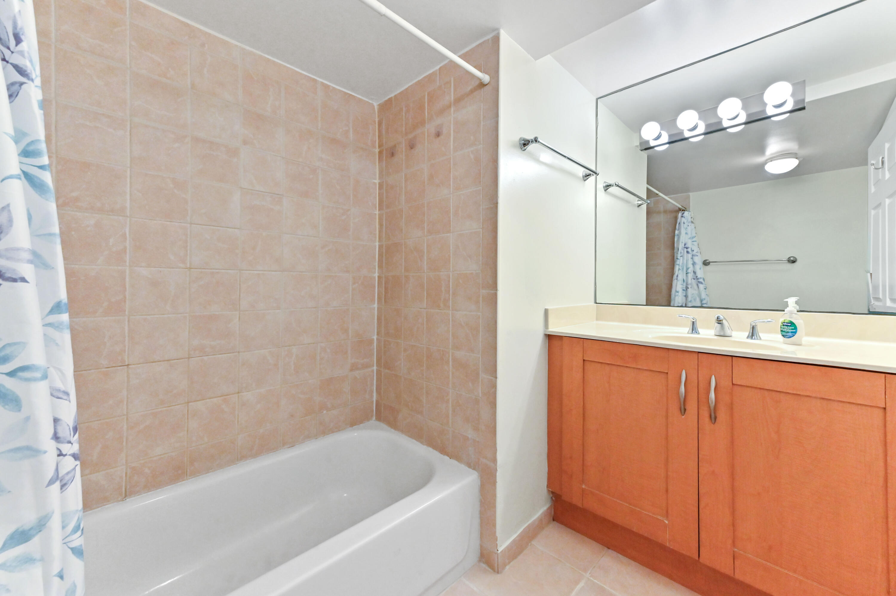 3237 Clint Moore Road, Unit 107 Boca Raton, FL 33496 - Photo 22 of 41 a bathroom with a bathtub a sink and a mirror