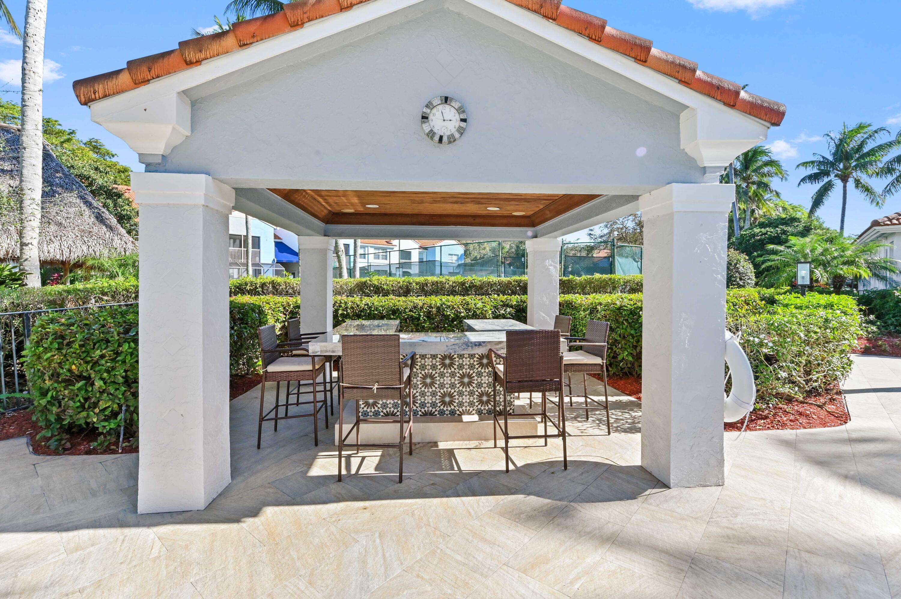 3237 Clint Moore Road, Unit 107 Boca Raton, FL 33496 - Photo 29 of 41 a view of a patio with table and chairs potted plants and floor to ceiling window
