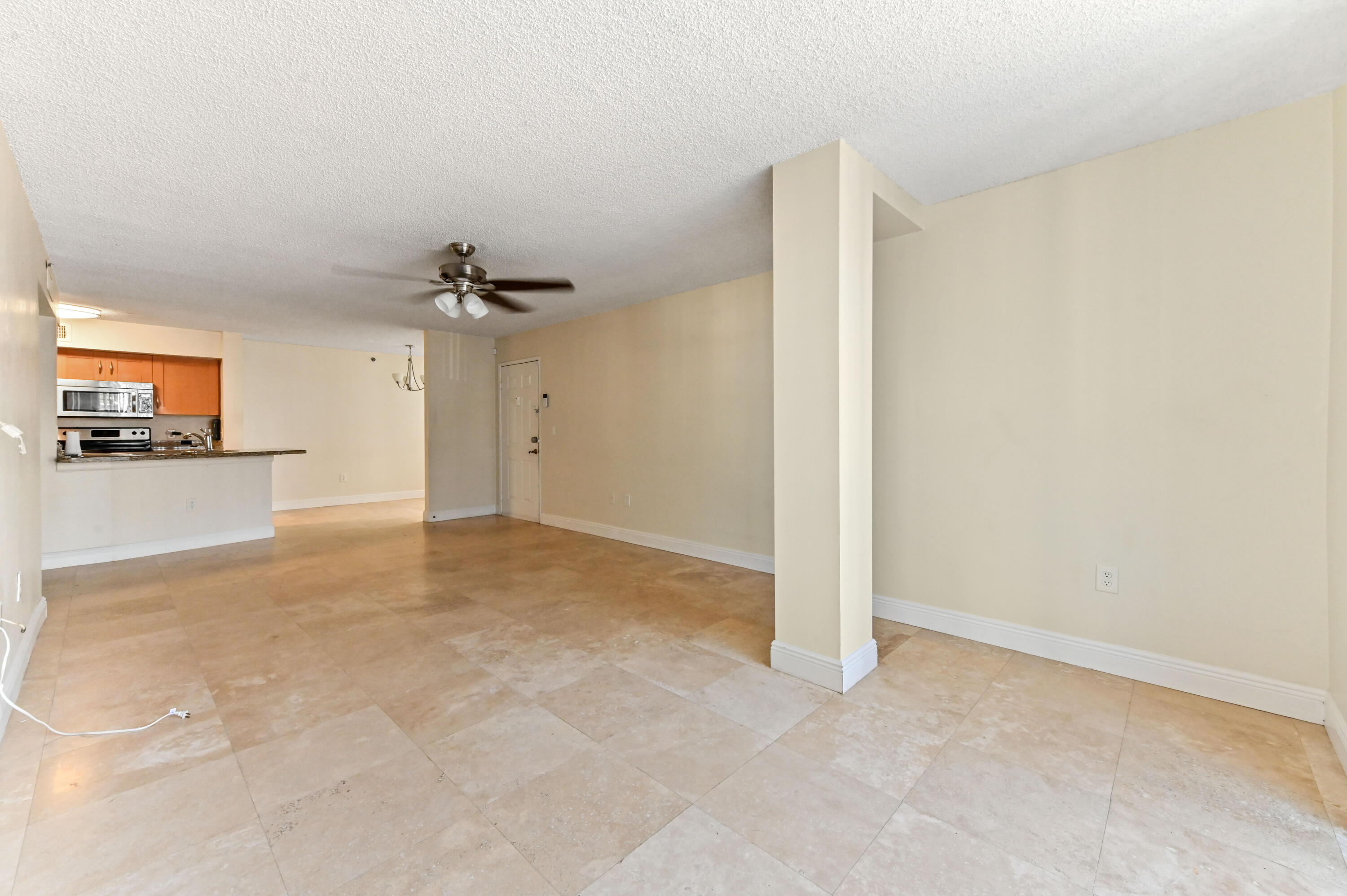 3237 Clint Moore Road, Unit 107 Boca Raton, FL 33496 - Photo 6 of 41 a view of a room with a refrigerator and a flat screen tv