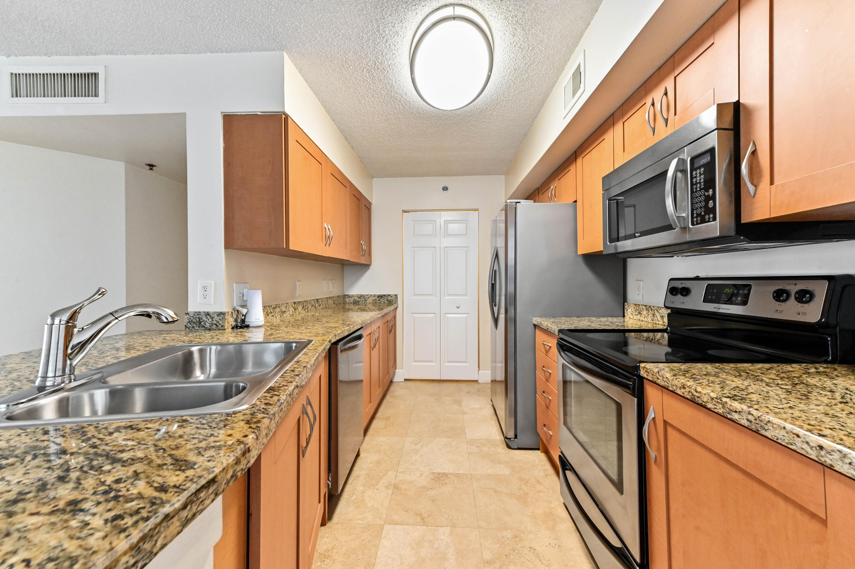 3237 Clint Moore Road, Unit 107 Boca Raton, FL 33496 - Photo 8 of 41 a kitchen with stainless steel appliances granite countertop a sink stove and cabinets