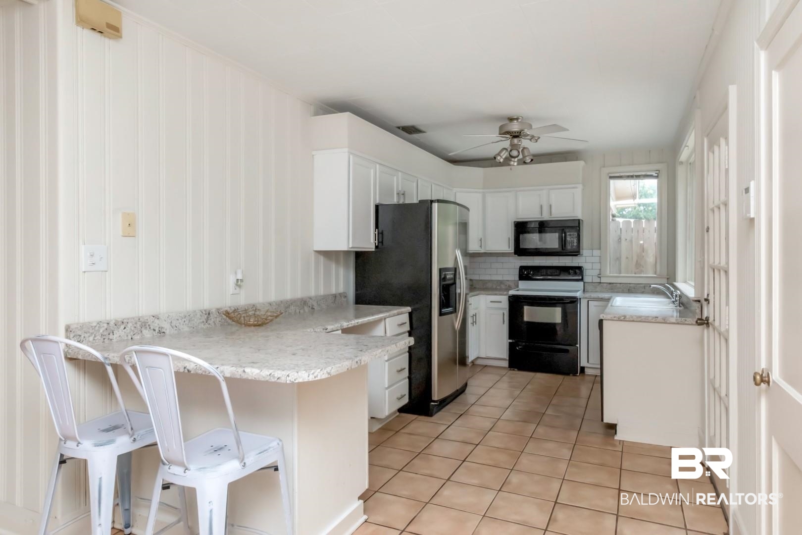 1906 Old Shell Road Mobile, AL 36607 - Photo 10 of 26 Kitchen with ceiling fan, electric range, white cabinets, and stainless steel refrigerator with ice dispenser