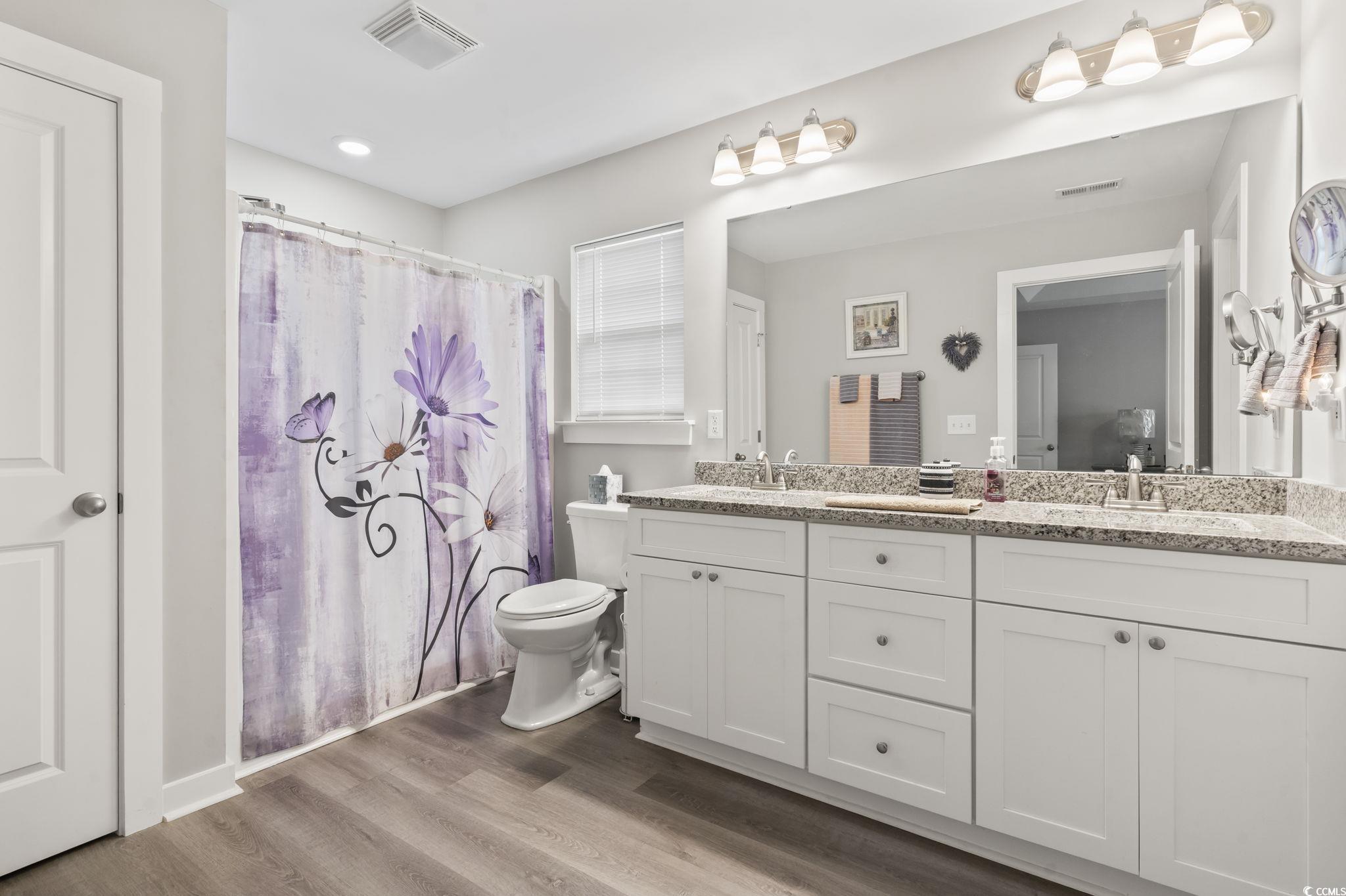 2715 Biscane Court Conway, SC 29527 - Photo 11 of 18 Full bath with double vanity, curtained shower, and dark wood-style floors
