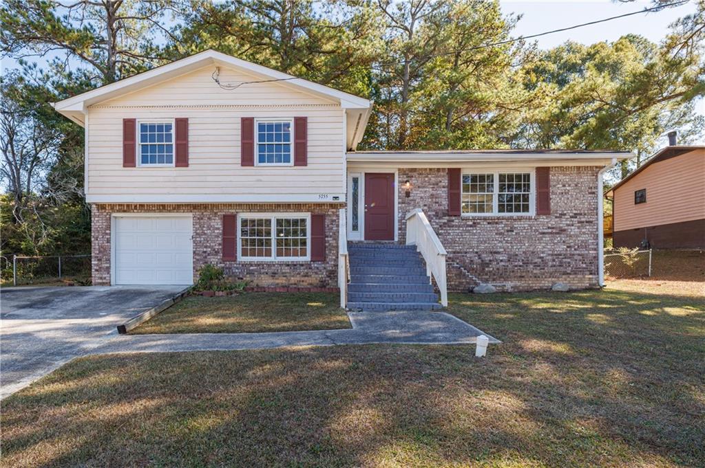 5755 Bearing Way Atlanta, GA 30349 - Photo 2 of 31 a front view of a house with a yard and garage