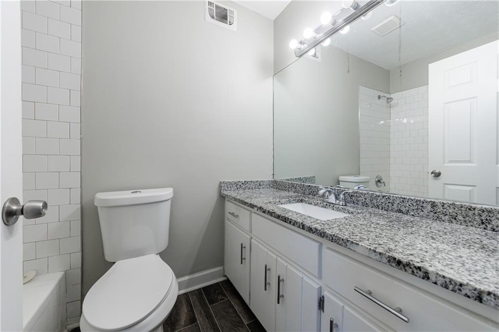 5755 Bearing Way Atlanta, GA 30349 - Photo 24 of 31 a bathroom with a granite countertop toilet sink and mirror