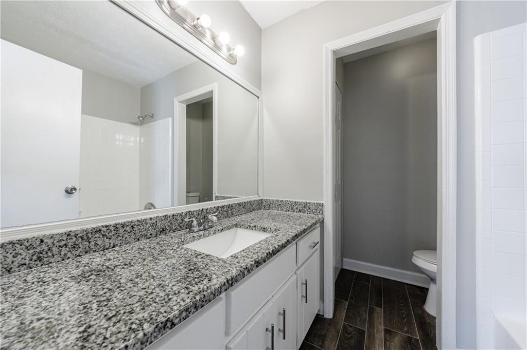5755 Bearing Way Atlanta, GA 30349 - Photo 26 of 31 a bathroom with a granite countertop sink and a mirror