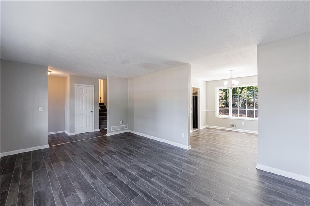 5755 Bearing Way Atlanta, GA 30349 - Photo 5 of 31 a view of an empty room with wooden floor and windows