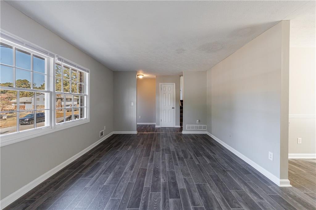 5755 Bearing Way Atlanta, GA 30349 - Photo 6 of 31 a view of an empty room with wooden floor and a window