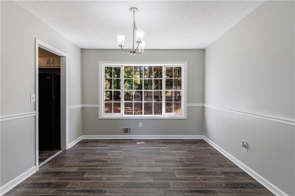5755 Bearing Way Atlanta, GA 30349 - Photo 7 of 31 a view of an empty room with wooden floor and a window