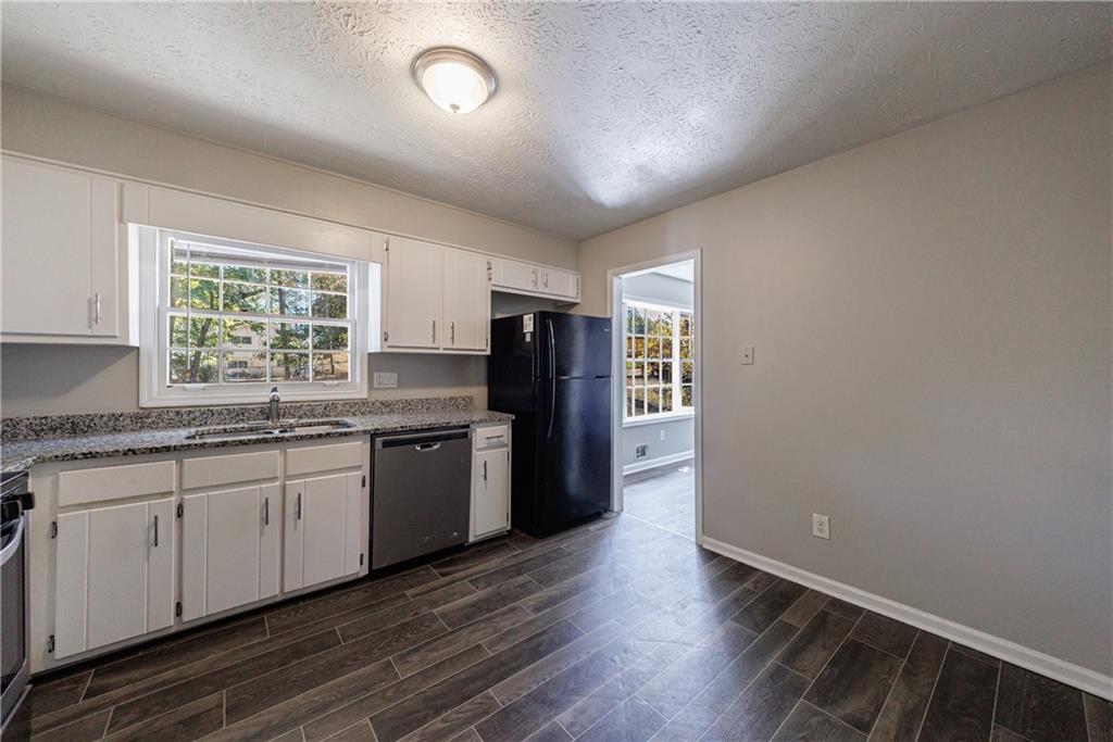 5755 Bearing Way Atlanta, GA 30349 - Photo 9 of 31 a kitchen with granite countertop a refrigerator and a sink