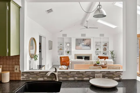 a kitchen with a sink and a stove with wooden floor