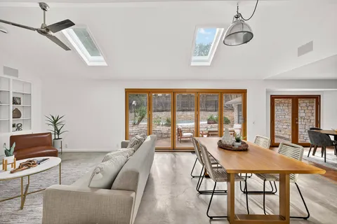 a living room with furniture a flat screen tv and a large window