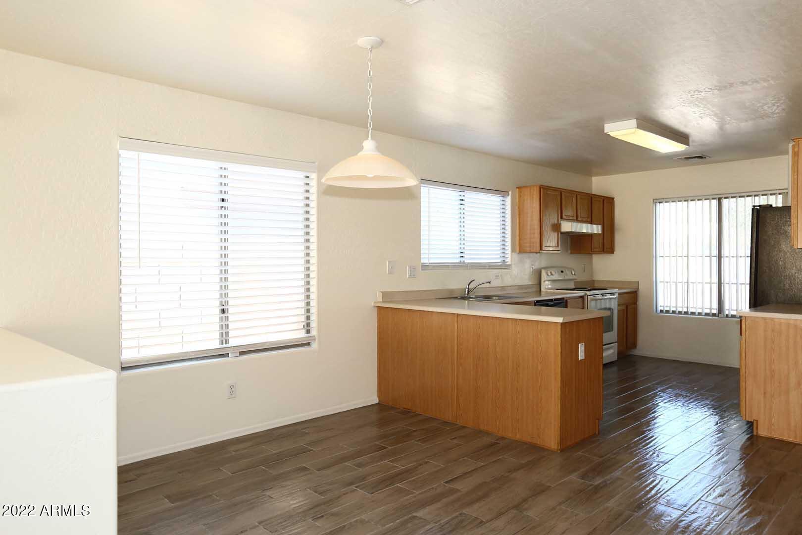 4319 West Carson Road Laveen, AZ 85339 - Photo 10 of 36 a kitchen with stainless steel appliances granite countertop a sink cabinets and wooden floor
