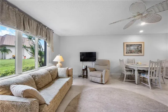 a living room with furniture a flat screen tv and a large window