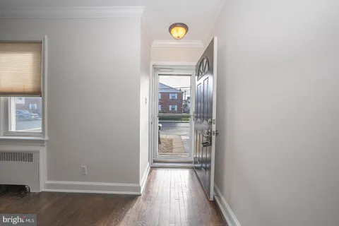 a view of hallway with wooden floor and chandelier