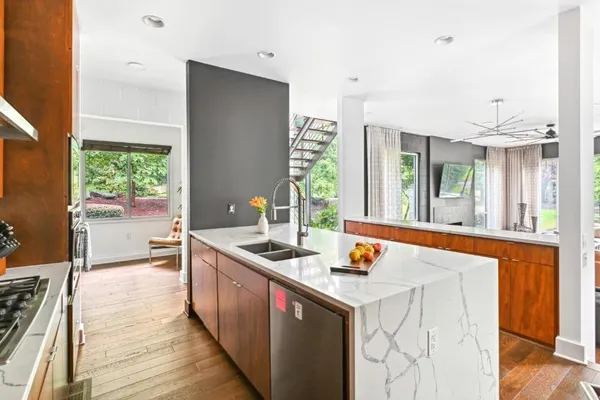 a kitchen that has a sink and chairs in it