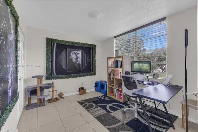a work room with furniture a rug and a window