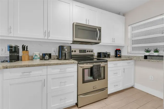 a kitchen with white cabinets stainless steel appliances and sink