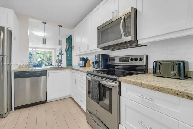 a kitchen with stainless steel appliances granite countertop a stove and a microwave