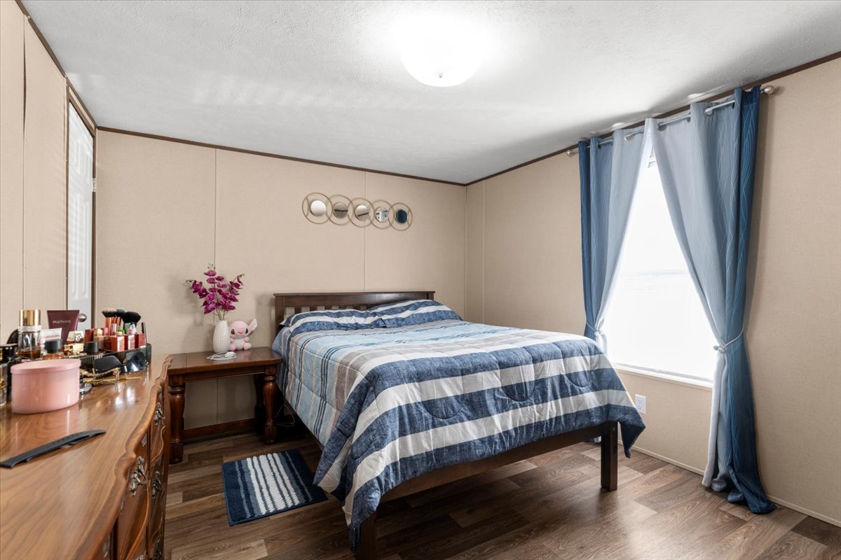 341 Southwest Front Street Bartlett, TX 76511 - Photo 8 of 23 a bedroom with a bed and a dresser with wooden floor