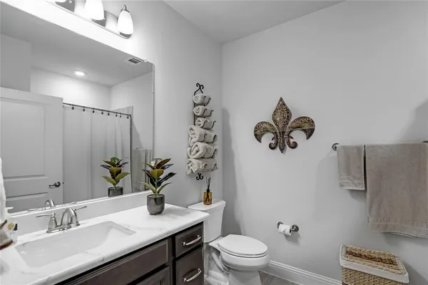 a bathroom with a granite countertop sink a toilet and mirror