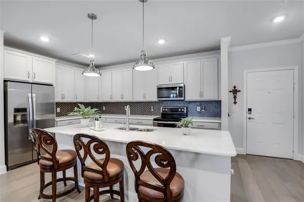 a kitchen with kitchen island a stove a table and chairs