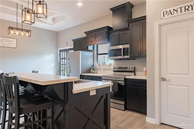 a kitchen with stainless steel appliances a stove a sink island and a refrigerator