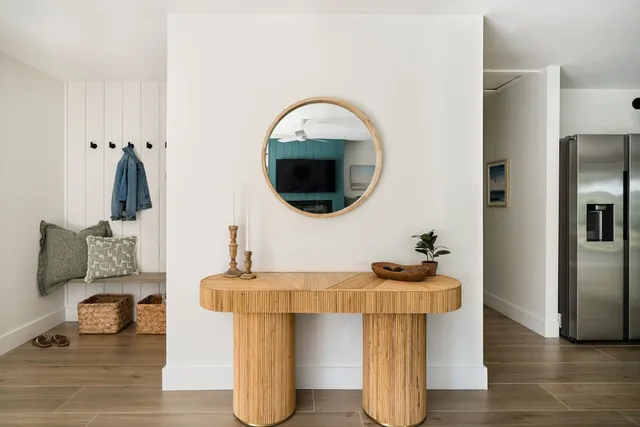 a large white kitchen with white cabinets and wooden floor