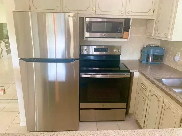 a kitchen with stainless steel appliances a refrigerator stove and microwave