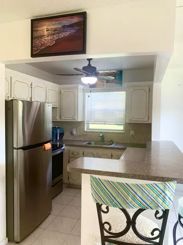 a kitchen with kitchen island a counter top space appliances and cabinets