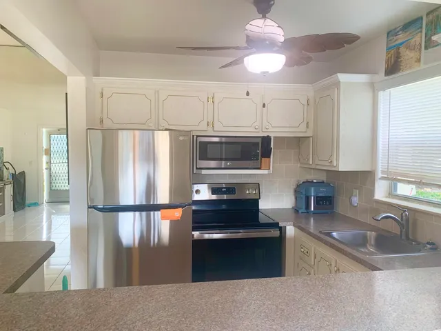 a kitchen with stainless steel appliances granite countertop a refrigerator a sink and a stove