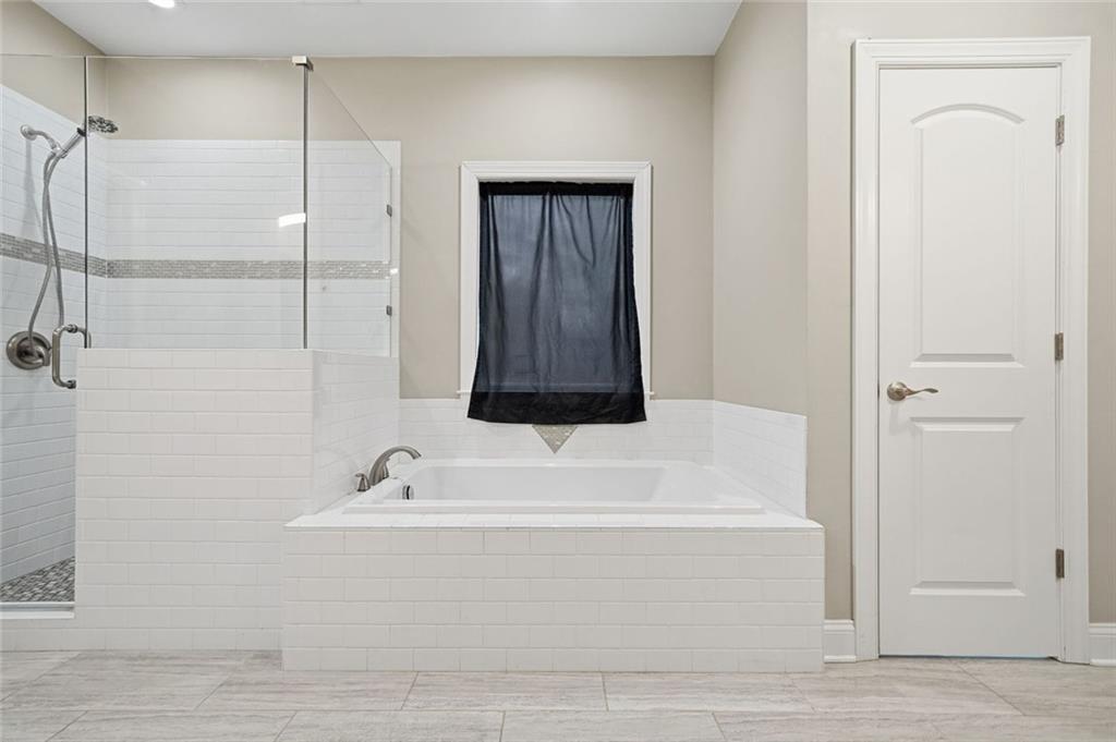 1006 Owens Store Road Canton, GA 30115 - Photo 25 of 48 a bathroom with a bathtub and a shower