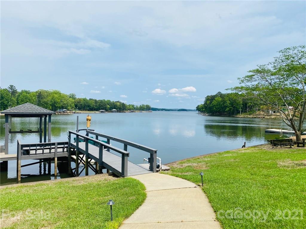 437 State Rd S-20-457 Ridgeway, SC 29130 - Photo 44 of 48 a view of a lake with table and chairs under an umbrella next to a yard