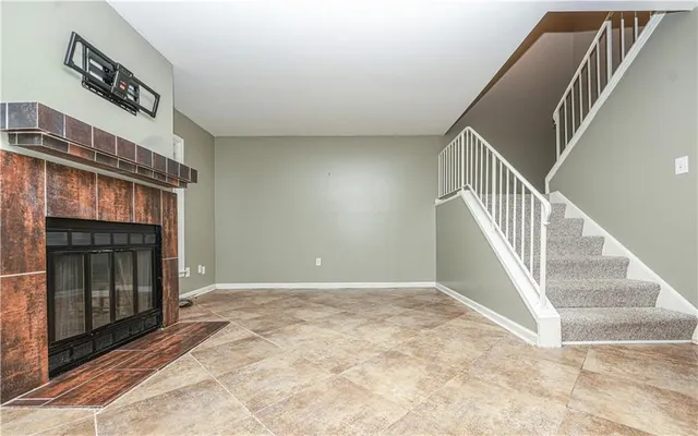 a view of an empty room with window and fireplace