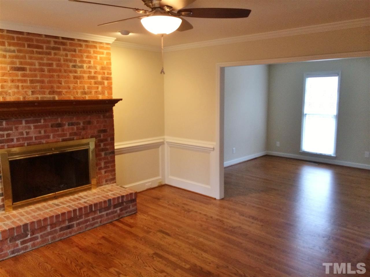 3344 Harden Road Raleigh, NC 27607 - Photo 14 of 25 a view of an empty room with wooden floor fireplace and a window