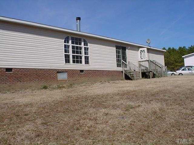 8762 Creek Road Willow Spring, NC 27592 - Photo 3 of 3 a front view of a house with a yard and garage