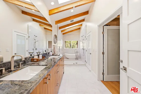 a large white kitchen with a large window and stainless steel appliances