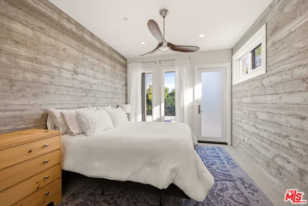 a spacious bedroom with a bed and a chandelier